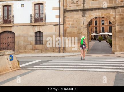 Pilgrim walking the Camino de Santiago the way of St James pilgrimage route through the Spanish town of Los Arcos Navarre Spain Stock Photo