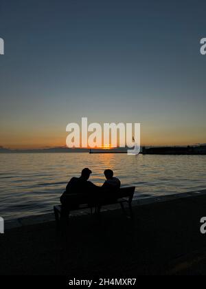 A senior couple in silhouette, enjoying the sunset at the lake Stock ...