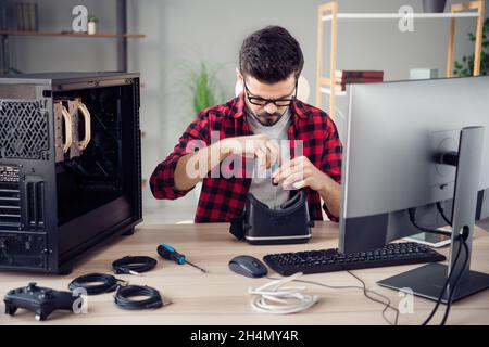 Portrait of attractive focused smart skilled guy fixing vr cyberspace guarantee at studio office work place station indoor Stock Photo