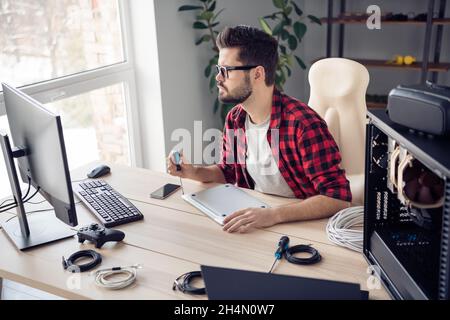 Profile side view portrait of attractive experienced focused guy repairing device brainstorming at office work place station indoor Stock Photo