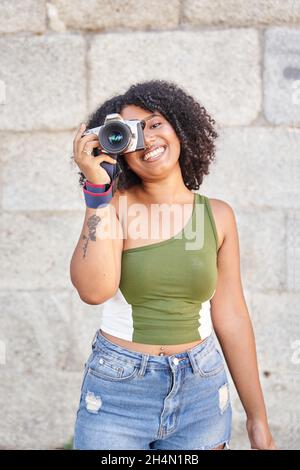 woman photographer with curly hair takes images with dslr camera Stock Photo