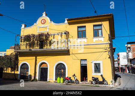 Akhisar, Manisa, Turkey – November 9, 2020. Historic yellow-colored building in Akhisar town of Manisa province in Turkey. View with motorbikes on a s Stock Photo