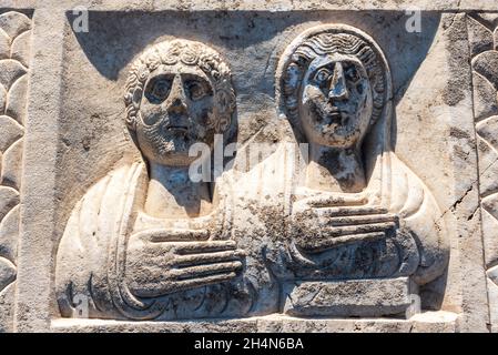 Cavdarhisar, Kutahya, Turkey – November 17, 2020. Phrygia type family grave stele, depicting heads of a man and a woman, at Aizanoi ancient site in Ku Stock Photo