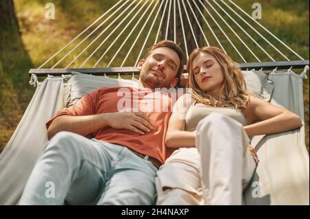Young couple napping on hammock in nature Stock Photo