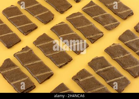 Banana and cocoa chocolate wafer roll snacks on yellow background Stock Photo