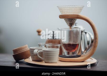 https://l450v.alamy.com/450v/2h4nd5r/a-drip-coffee-set-with-a-steel-kettle-glass-and-hand-drip-coffee-maker-in-minimalist-style-with-the-fog-and-nature-background-2h4nd5r.jpg