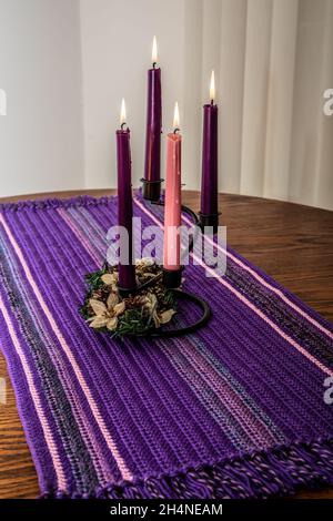 Advent candles with a flower wreath on a homemade crocheted table runner. Stock Photo