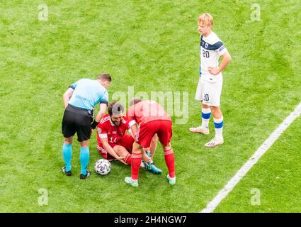 Saint Petersburg, Russia – June 16, 2021. Russia players Georgi Dzhikiya (on the pitch) and Roman Zobnin, Finland striker Joel Pohjanpalo and referee Stock Photo