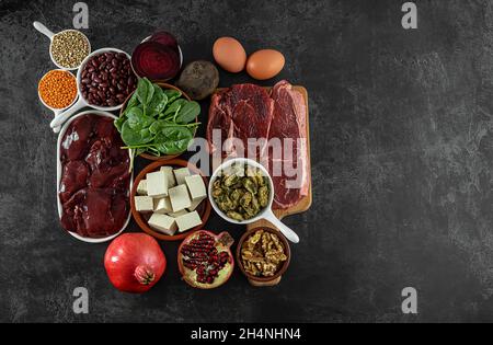 Foods high in Iron, including eggs, nuts, spinach, beans, tofu, liver, beef, beetroot, mussels, and dark chocolate.  Stock Photo
