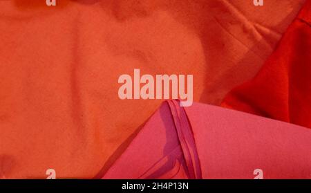 Three pieces of fabric in the colors red, orange and pink. Meant as background Stock Photo