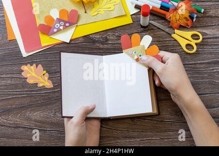 In the hands of a child Thanksgiving craft bookmark turkey paper. Childrens art project, handmade, crafts for kids. Stock Photo