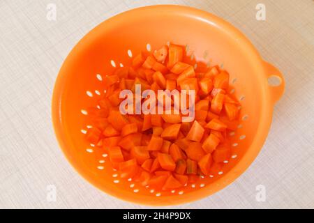 Pieces of carrot in an orange colander Stock Photo