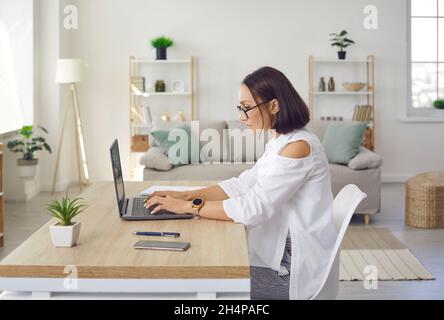 Serious, focused and dedicated woman doing business project on laptop in her home office. Stock Photo