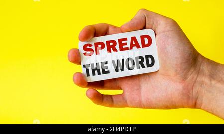 businessman holding a card with text SPREAD THE WORD Stock Photo