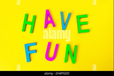 Have fun in colorful toy letters on yellow background Stock Photo