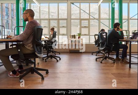 Group of diverse young businesspeople working at their desk in an office Stock Photo