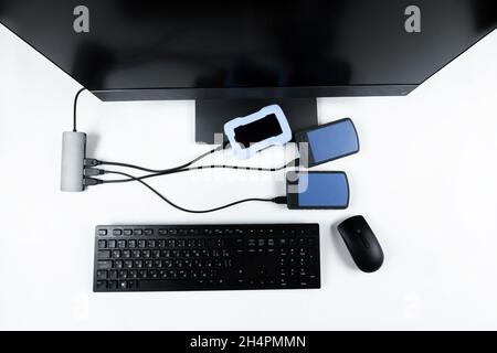 Multiple external hard drives connected to a monoblock on a white background.Computer with hard drive. Stock Photo