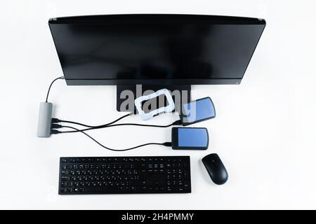 Multiple external hard drives connected to a monoblock on a white background.Computer with hard drive. Stock Photo