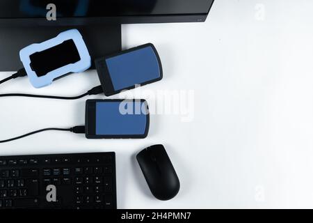 Multiple external hard drives connected to a monoblock on a white background.Computer with hard drive. Stock Photo