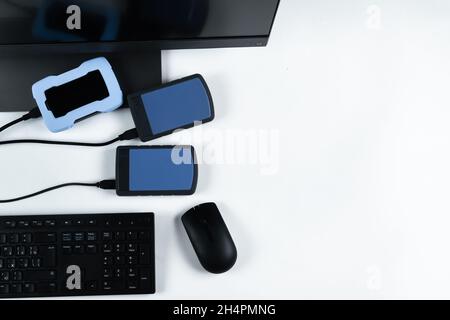 Multiple external hard drives connected to a monoblock on a white background.Computer with hard drive. Stock Photo