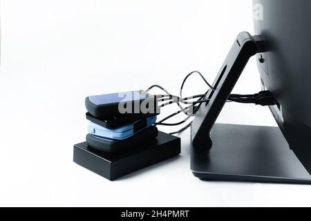 Multiple external hard drives connected to a monoblock on a white background.Computer with hard drive. Stock Photo