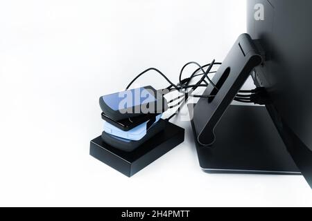 Multiple external hard drives connected to a monoblock on a white background.Computer with hard drive. Stock Photo