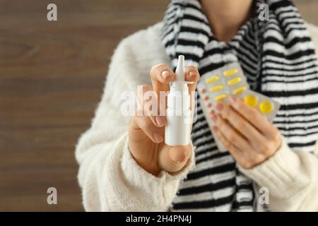 Woman holds nasal spray and pills, close up and selective focus Stock Photo