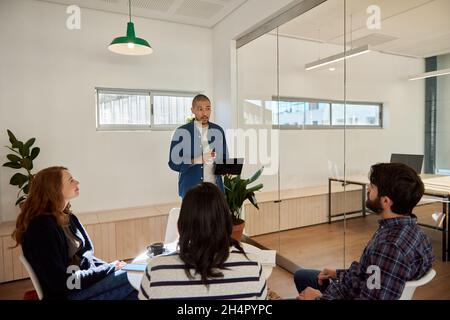 Young businessman doing a tablet presentation for colleagues in an office Stock Photo