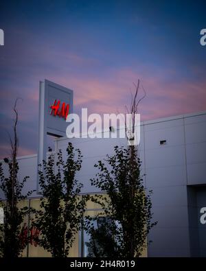 CALGAR, CANADA - Oct 06, 2021: A vertical shot of an H&M store sign against a sunset sky in Calgary, Alberta, Canada Stock Photo