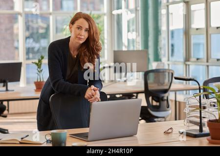 Focused businesswoman leaning on her chair in a modern office Stock Photo