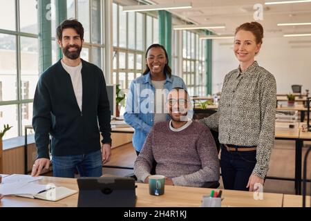 Smiling group of young businesspeople working together in an office Stock Photo