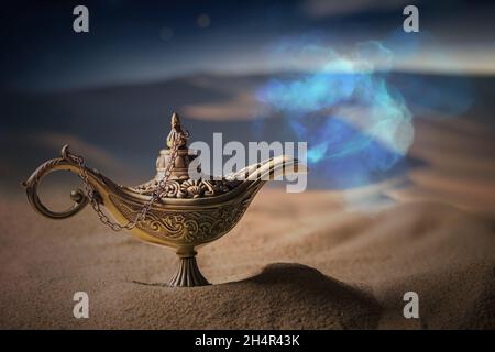 Magical Aladdin oil lamp with genie in desert at night. Stock Photo