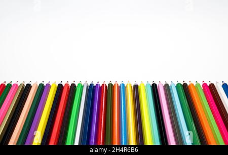 Creative back to school concept. Colored crayons against white background. Stock Photo