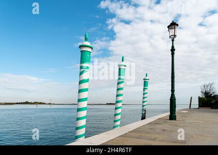 Three turquoise striped poles in Burano (Venice, Italy) on a sunny day in Autumn Stock Photo