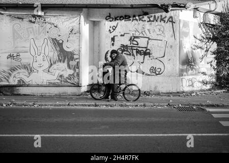 Belgrade, Serbia, Oct 31, 2021: An elderly cyclist resting on the sidewalk (B/W) Stock Photo