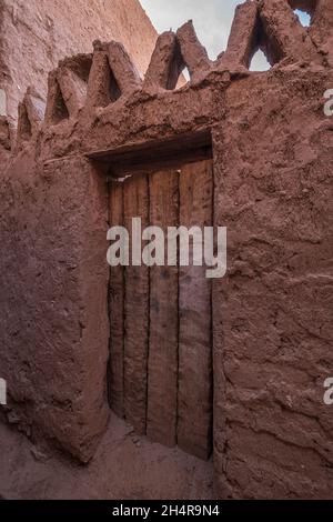 Old house with an artisanal wooden door in Taghit, Ksar Stock Photo