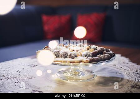 Traditional Christmas cookies with decorations on table at living room. Stock Photo