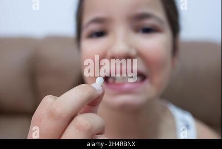 9 years old girl showing her first canine tooth fallen out. Selective focus Stock Photo