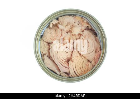 Canned tuna above. Pieces of fish inside of metallic can isolated on white background Stock Photo
