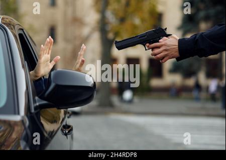 Police officer with gun arrests criminal driver Stock Photo