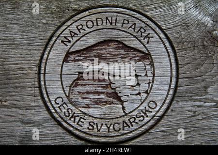 Seal of the National Park Bohemian Switzerland (Národní park České Švýcarsko) carved in wood on the backrest of a wooden bench Stock Photo