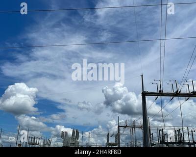 fenced in power transformers and tall power poles in Georgia Stock Photo