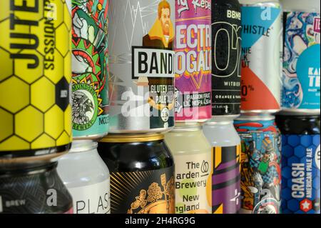 Closeup display of stacked craft beer cans by different breweries from around the world with colourful, creative wraparound designs. Stock Photo