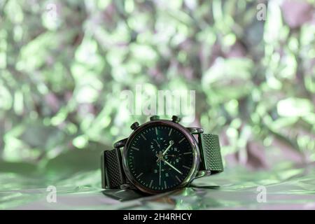 Black metal wristwatch with dark dials against a crisp lit background. High quality photo Stock Photo