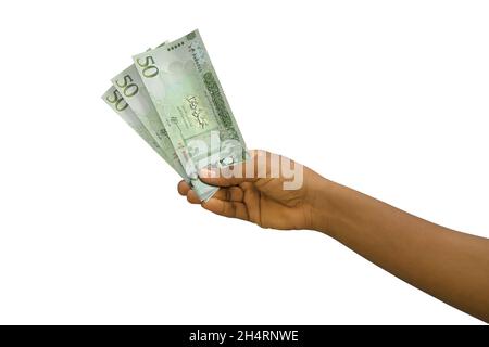 Fair hand holding 3D rendered Libyan dinar notes isolated on white background Stock Photo