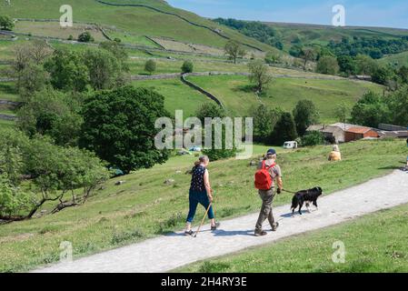 Walking Yorkshire, view in summer of a senior couple walking the Pennine Way in Malhamdale, an area of outstanding natural beauty in North Yorkshire Stock Photo