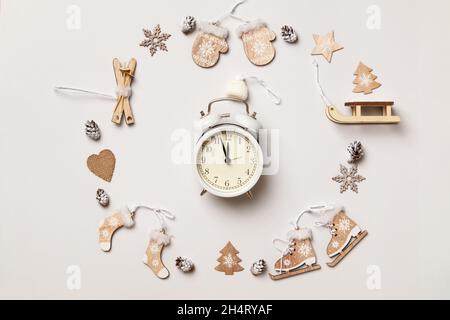 Winter composition. Alarm clock with wooden decorations on a gray background. Flat lay top view. Stock Photo