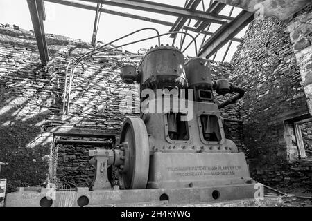 Monochrome view of old machinery in derelict, disused slate quarry building, North Wales, UK. Stock Photo