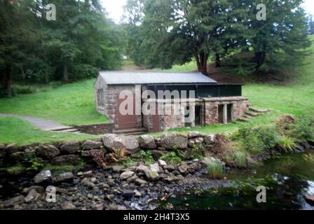Rocks lake and building near screw turbine at Cragside, Rothbury ...