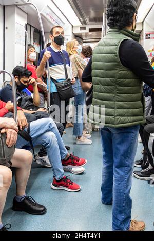 Barcelona, Spain - September 24, 2021: Crowds of people inside the subway. Interior view of a metropolitan train with passengers wearing protective ma Stock Photo